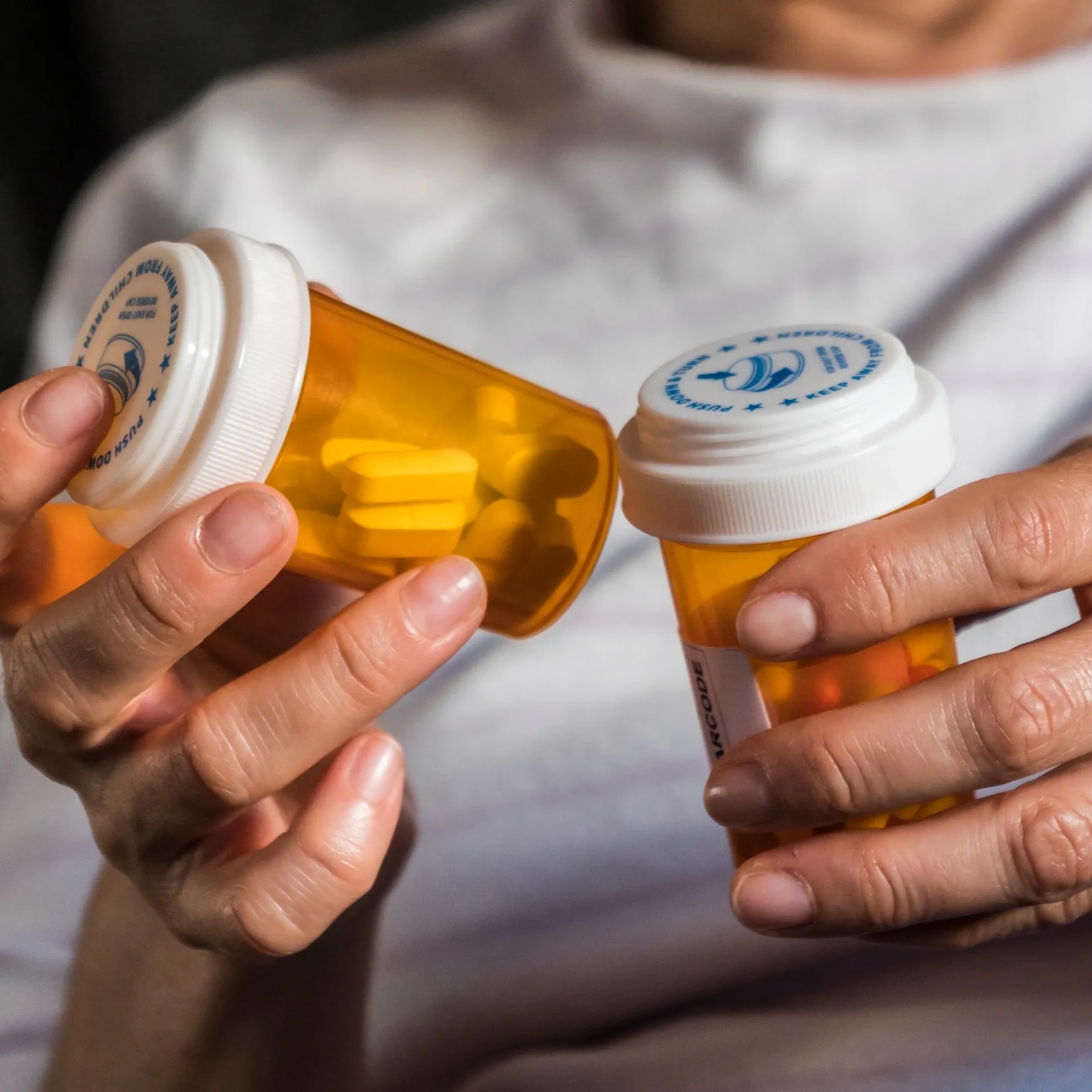 Senior looking at multiple medication bottles